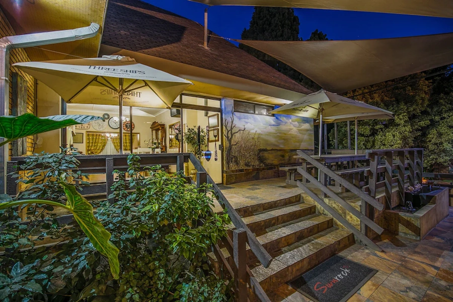 Sunrock Guesthouse in de avond buiten zitten.webp